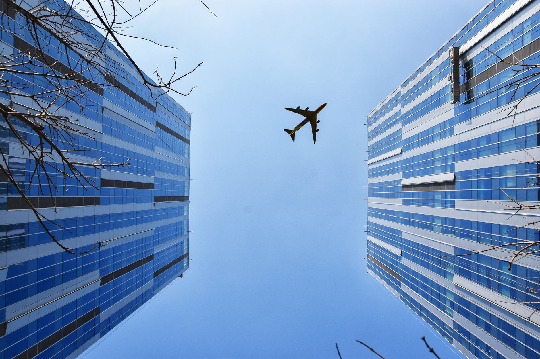 airplane near blue and grey building