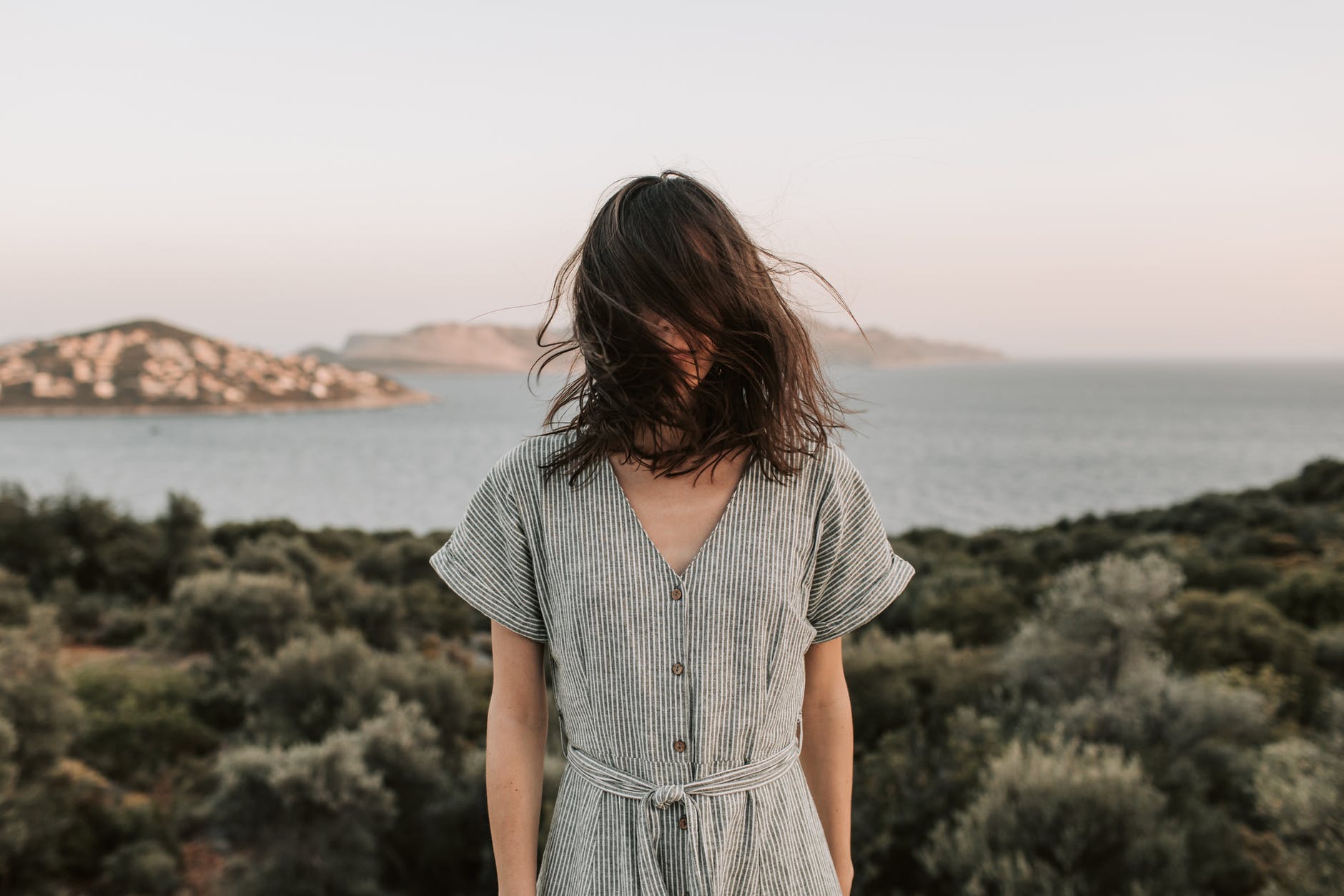 woman standing with face covered by her hair