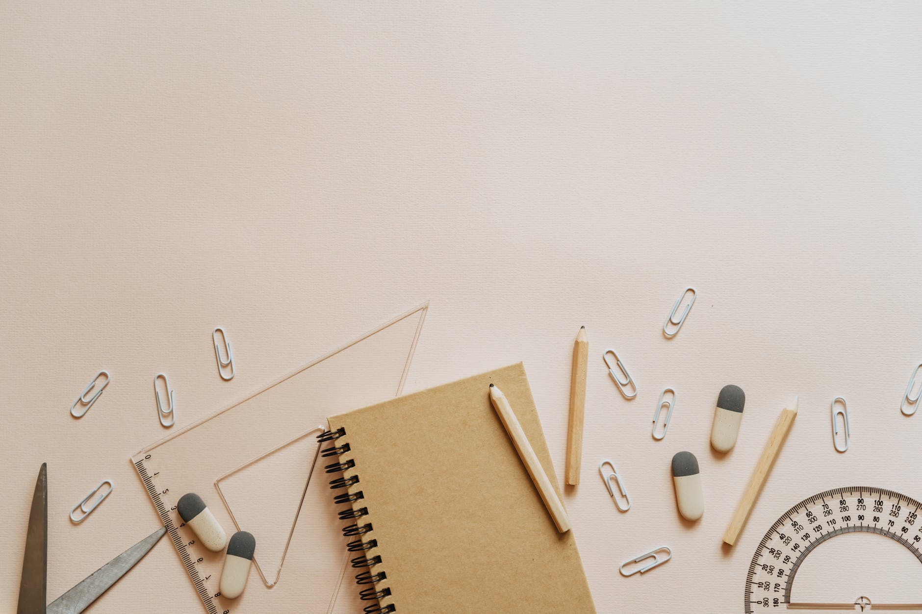 spiral notebook pencils and paper clips flatlay